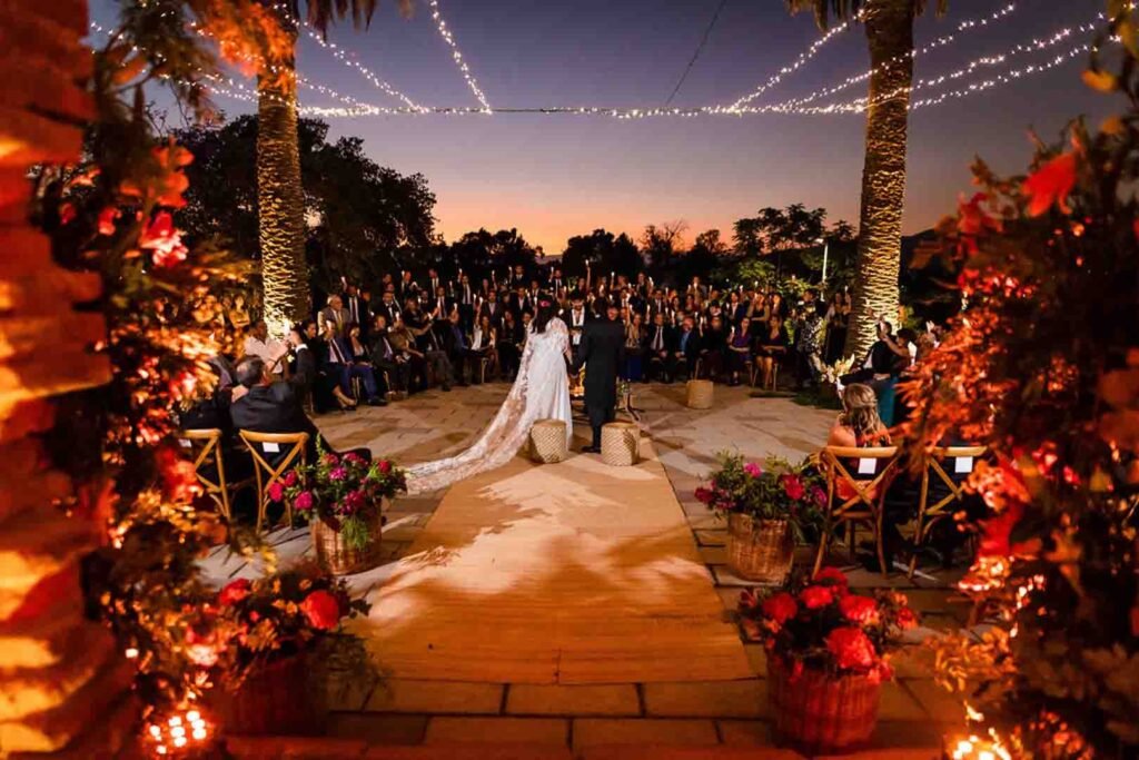 Ceremonia de matrimonio simbólico al atardecer con luces colgantes