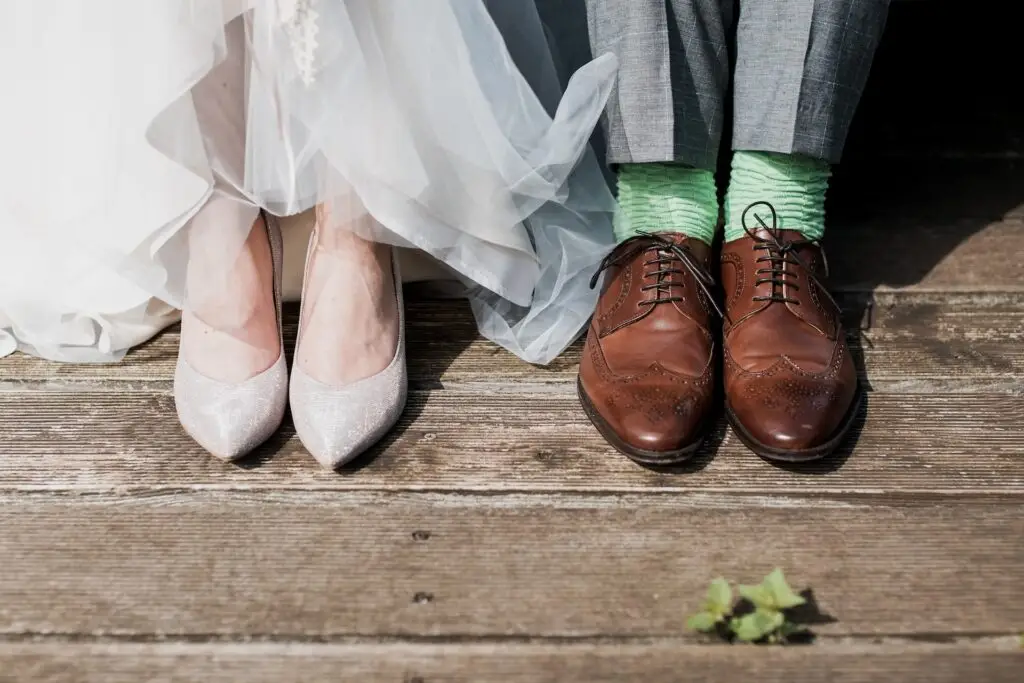 Los pies de dos novios sentados uno al lado del otro
